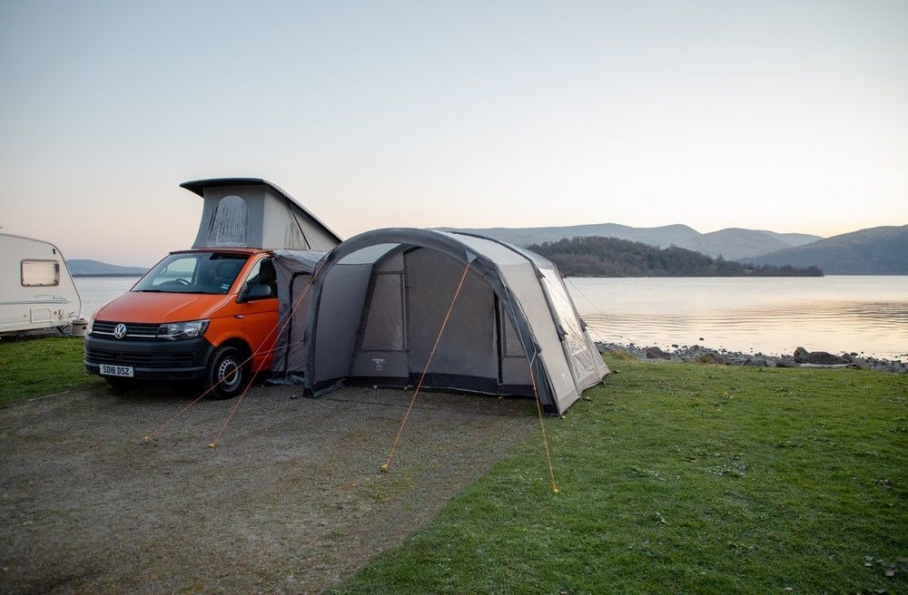 a campervan is parked with an awning attached