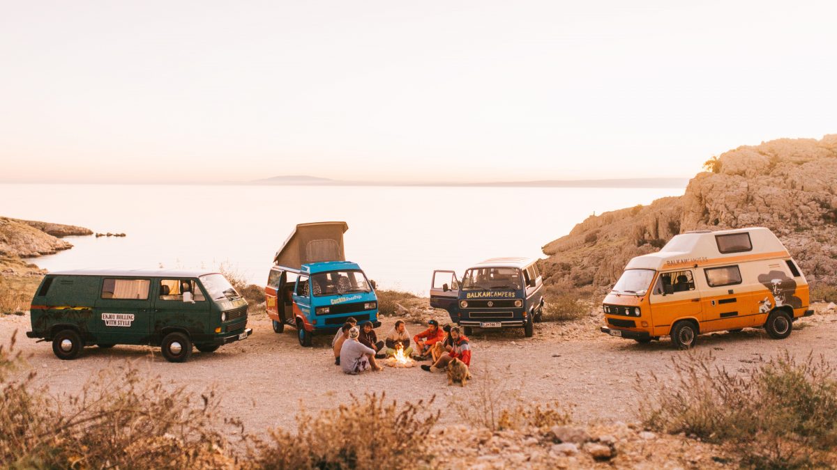a group of converted campervans parked on a cliff top