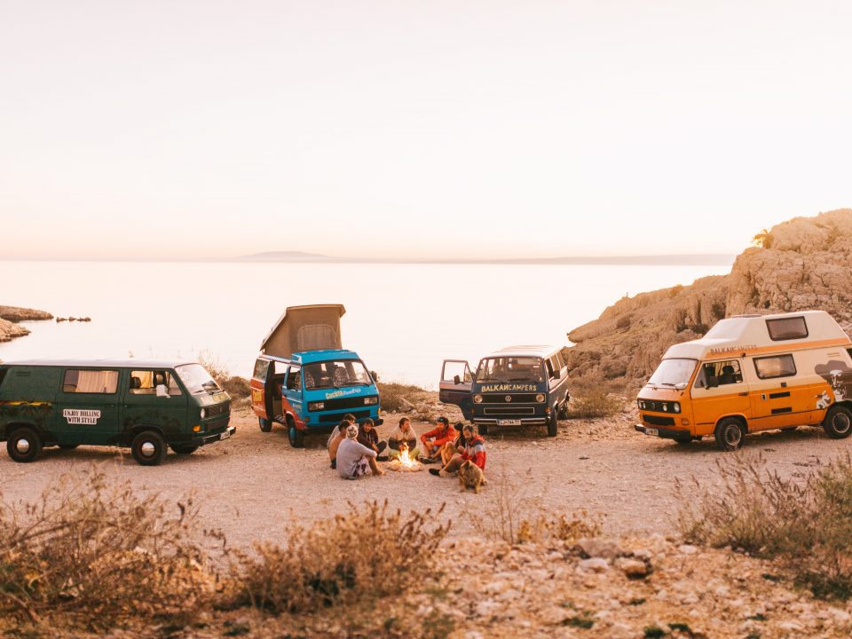 a group of converted campervans parked on a cliff top