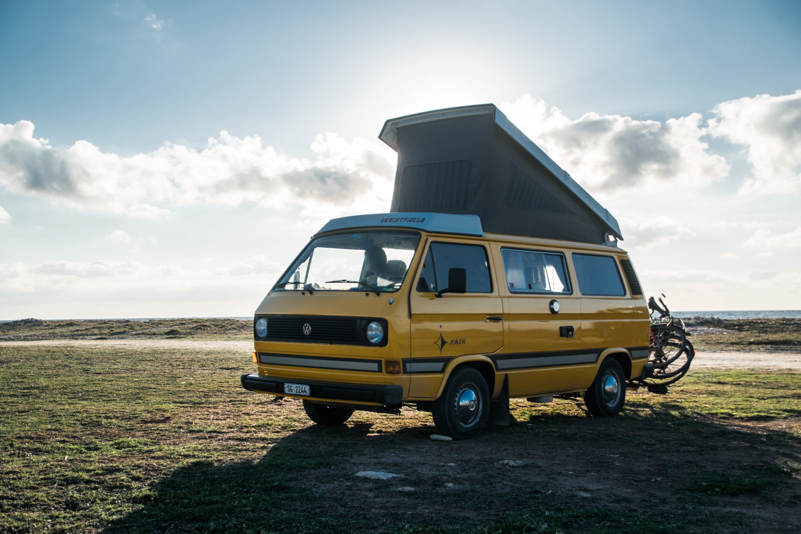 a yellow campercan parked with the roofspace open