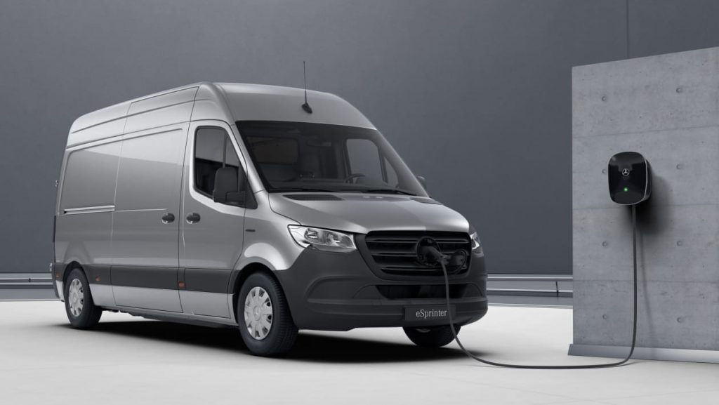 a silver Mercedes eSprinter plugged into an electric charging point