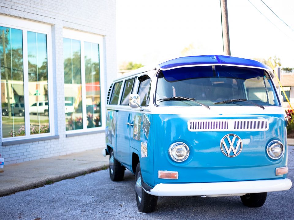 a bright blue VW camper parked in the sunshine