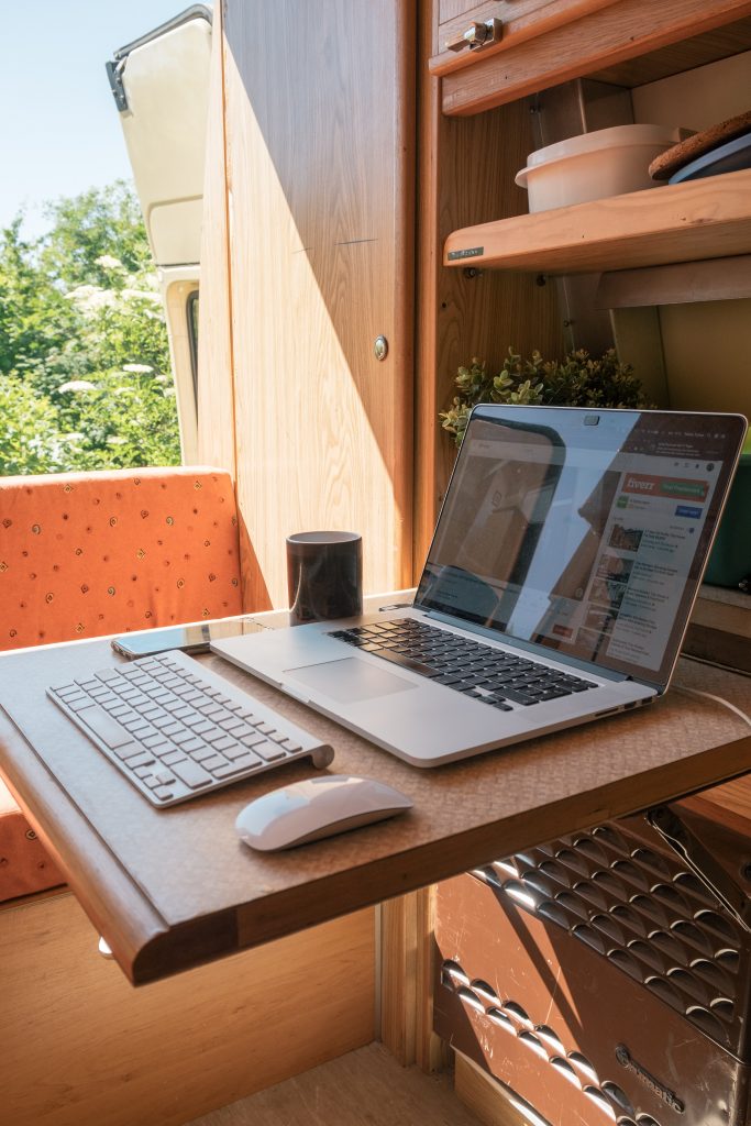 a folding desk area with a laptop in a campervan