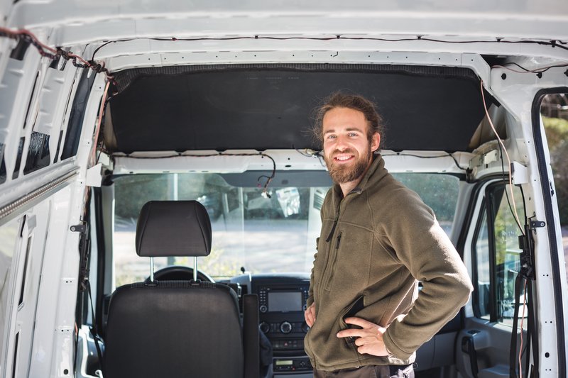 man in empty van shell ready for conversion to a campervan