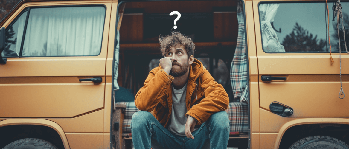 man sitting on side of campervan with question mark above his head